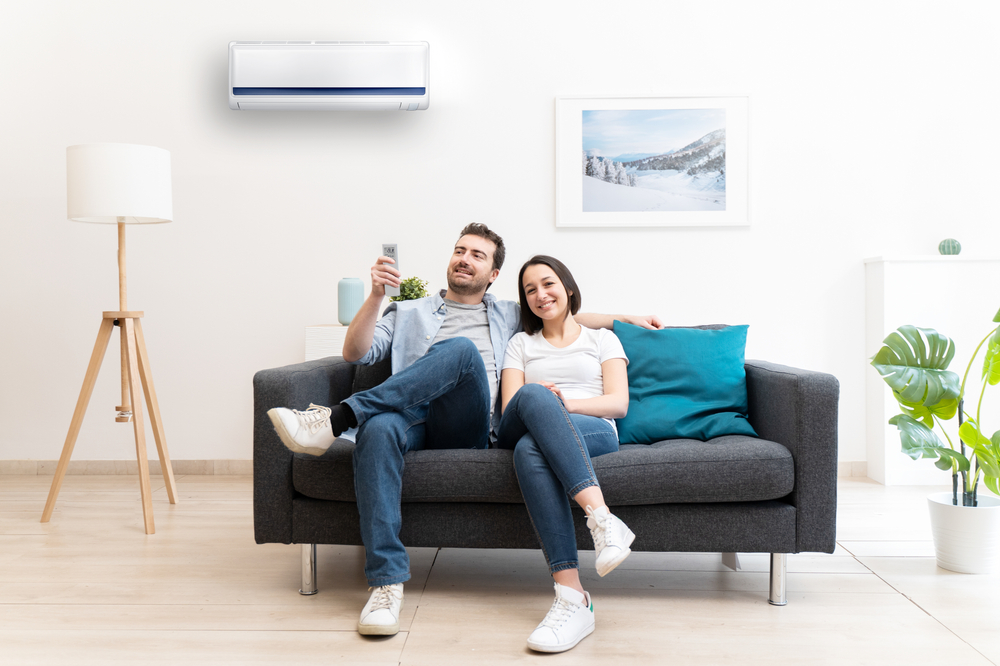 Happy,Couple,Freshen,Up,Using,Air,Conditioner,At,Home