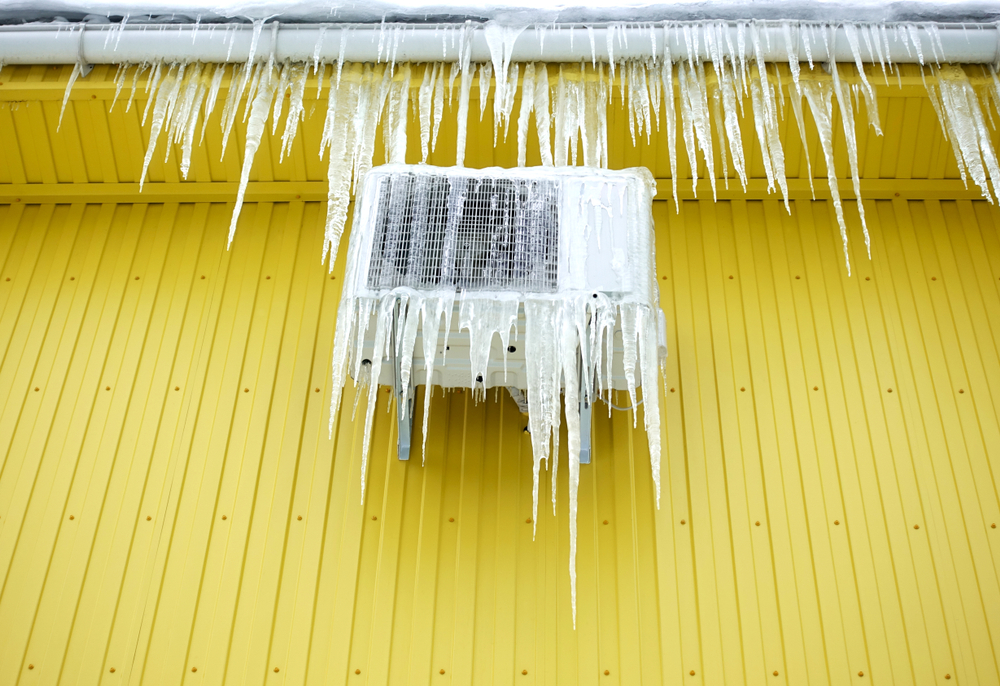 Frozen,Air,Conditioner,In,Ice,Icicles,On,A,Yellow,Wall.