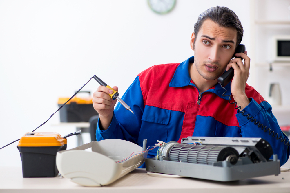 Young,Repairman,Repairing,Air-conditioner,At,Warranty,Center