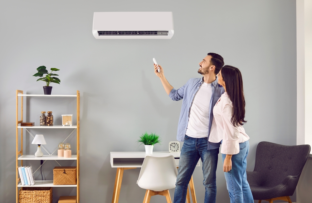 Young,Family,Couple,Using,Their,Modern,Air,Conditioning,System,At
