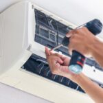 Repairman,Using,A,Screwdriver,Fixing,Modern,Air,Conditioner,,Male,Technician