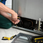Male,Technician,With,Pliers,Repairing,Refrigerator,Indoors,,Closeup