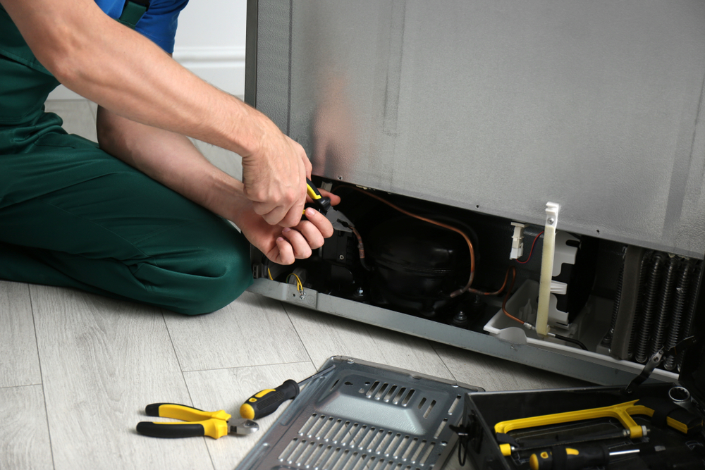 Male,Technician,With,Pliers,Repairing,Refrigerator,Indoors,,Closeup